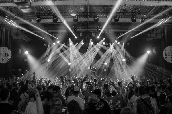 Packed indoor concert with raised hands