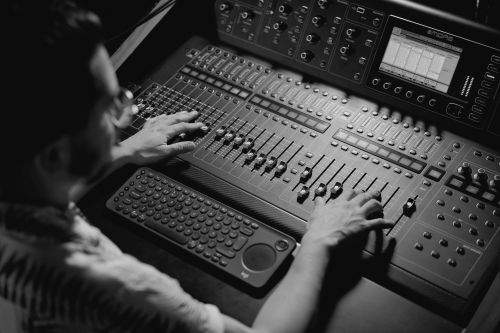 Person operating a professional audio mixing desk